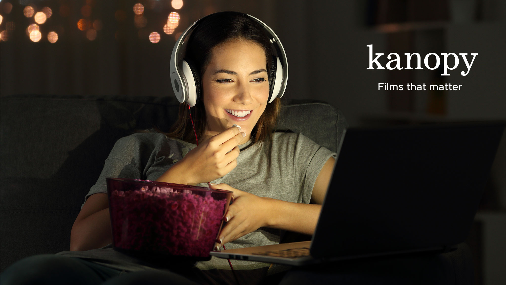 A woman enjoys streaming a movie on Kanopy